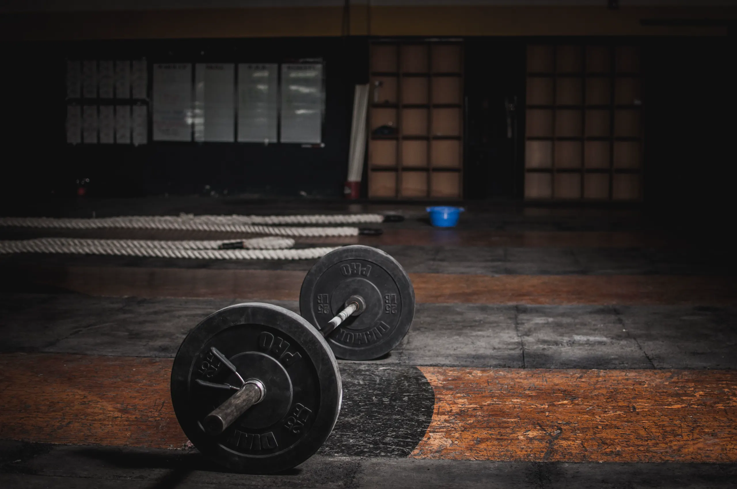 Barbells prepared in a quiet, dimly lit training space